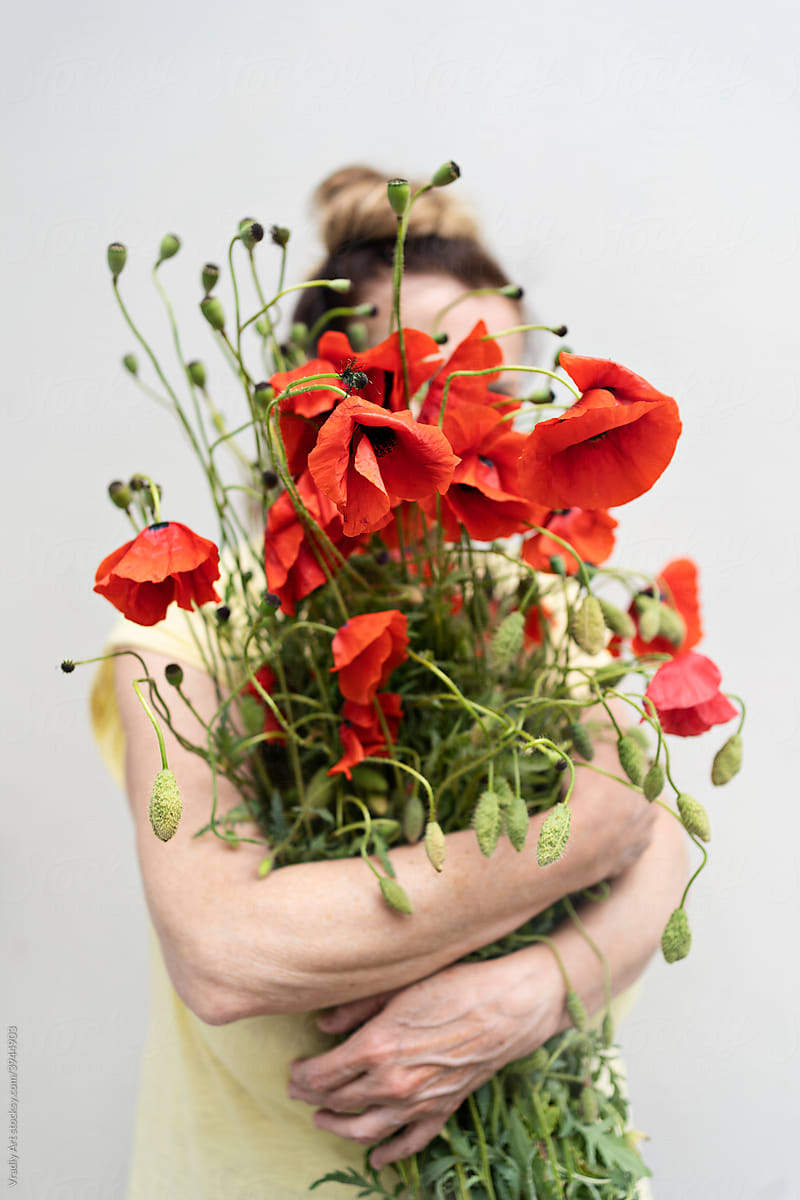 Woman with a bouquet of wild poppies