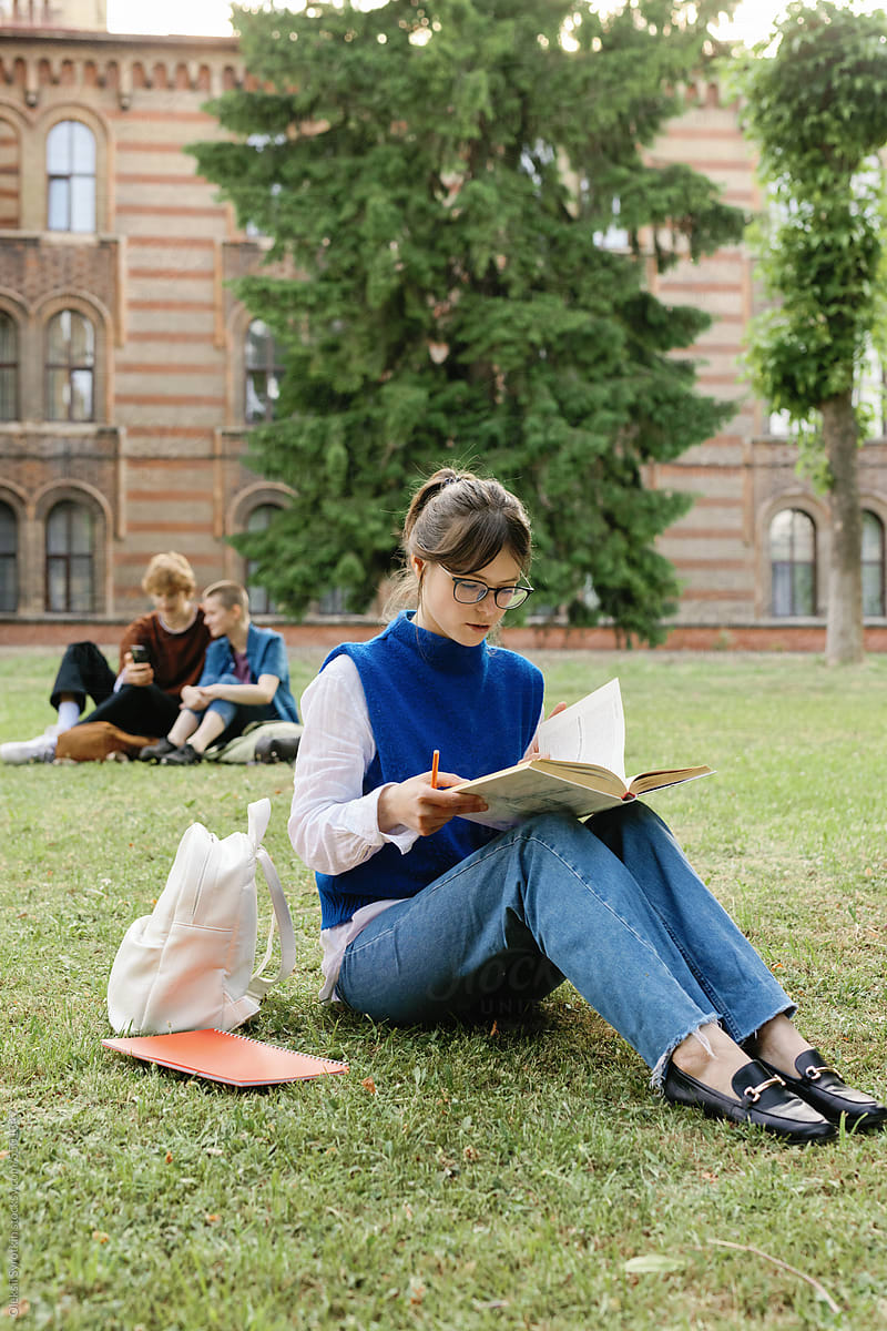 Concentrated university student studying dormitory garden lawn