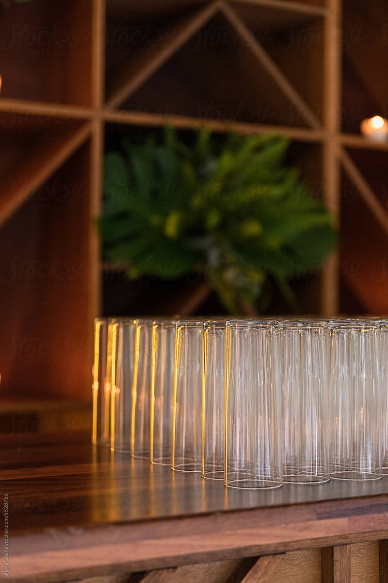 Tall glasses placed on a wood bar counter