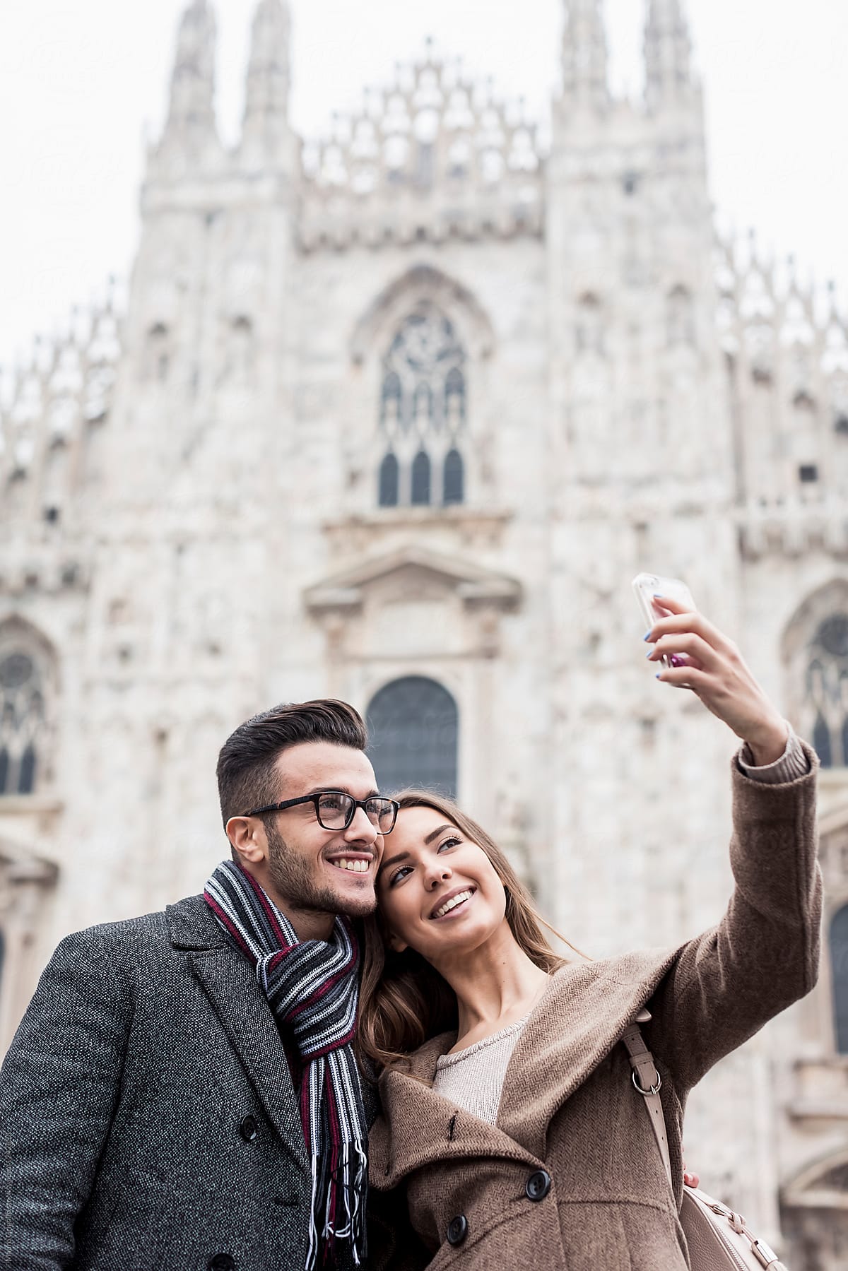 Smiling couple taking a selfie in Milan, Italy.