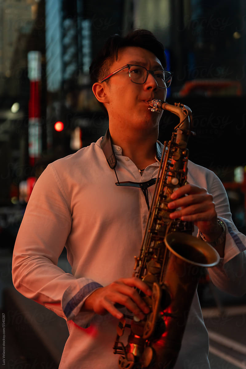 Talented Musician Playing The Saxophone On The Street At Night