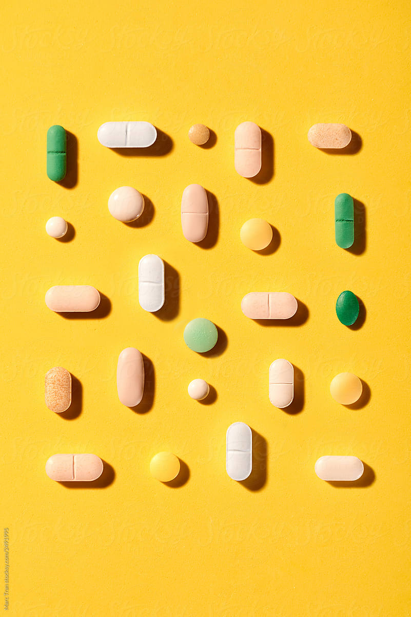 Heap of tablets pill on yellow table