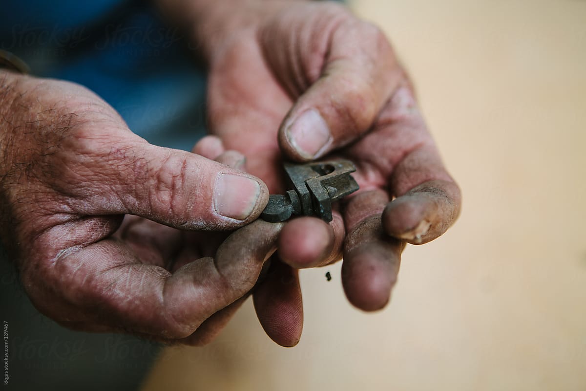 workmans hands holding lock.