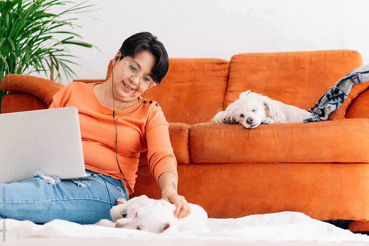 Mature woman with her pets and working at home.