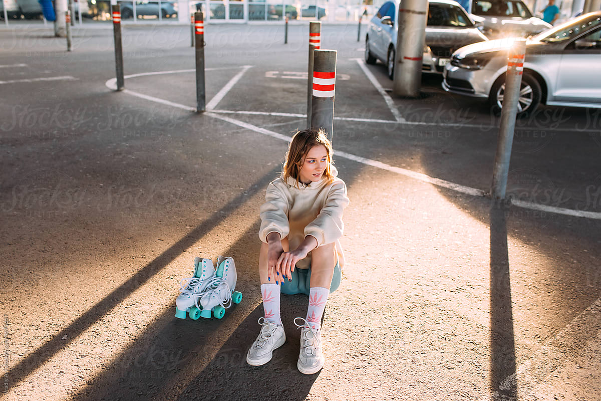 Stylish lady resting at parking space after roller skating