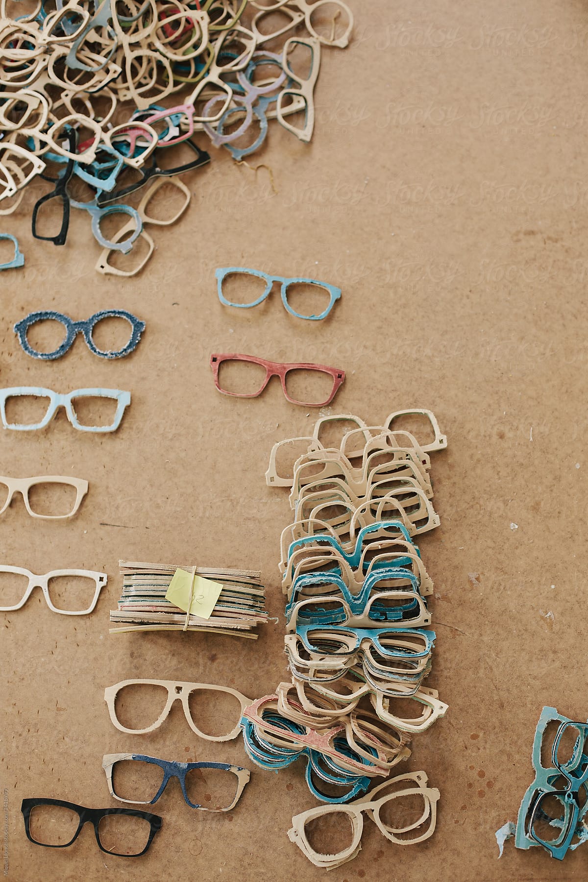 Handmade eyeglasses frames stacked on a wooden table