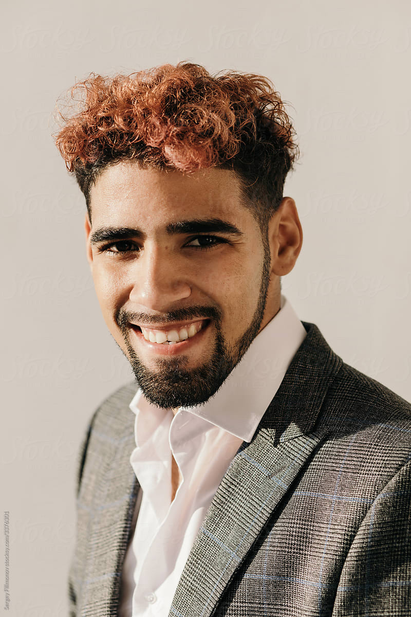 Positive young ethnic businessman in formal wear