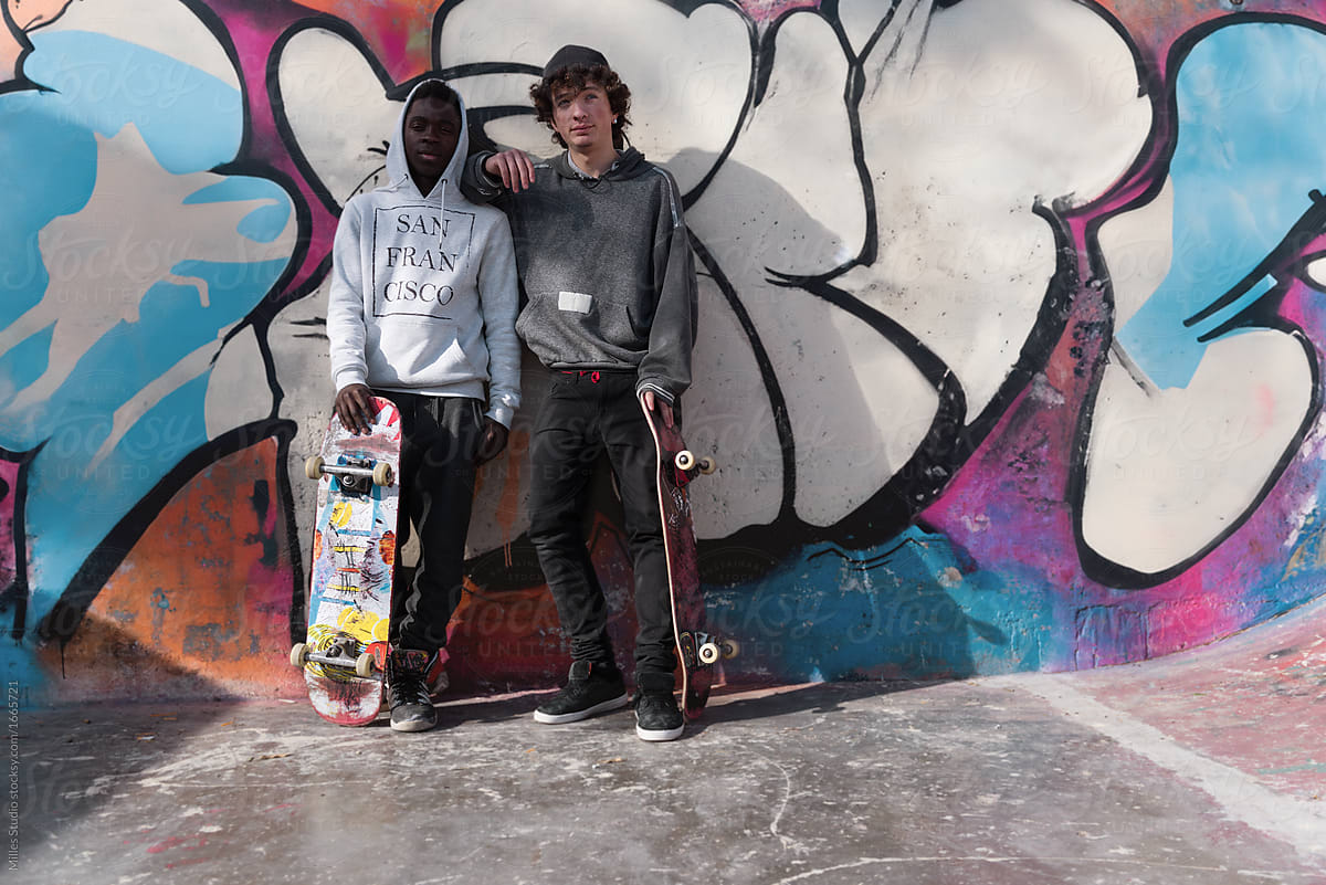 Young skateboarders at graffiti wall