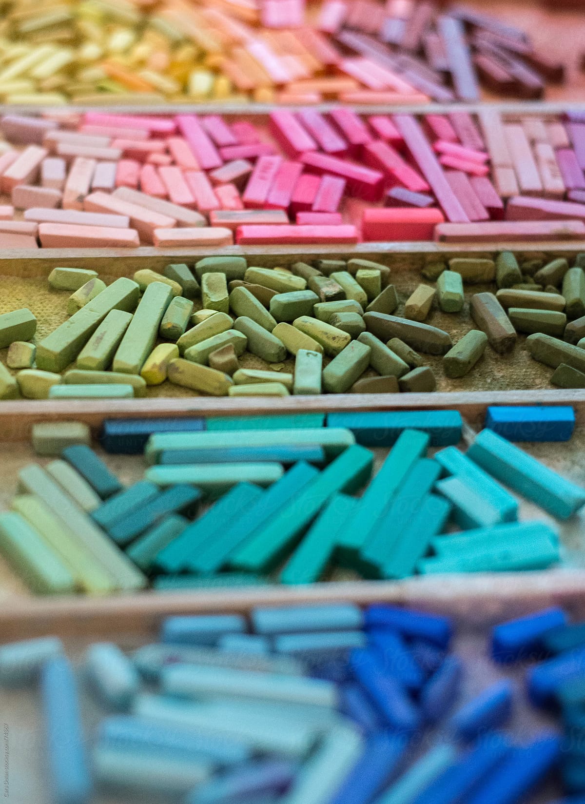 Artist's pastels organized by color on a tray