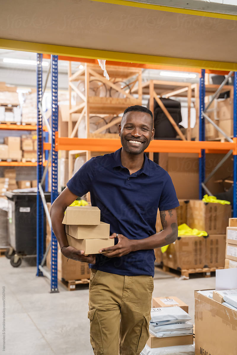 Smiling Man Holding Parcels At Warehouse