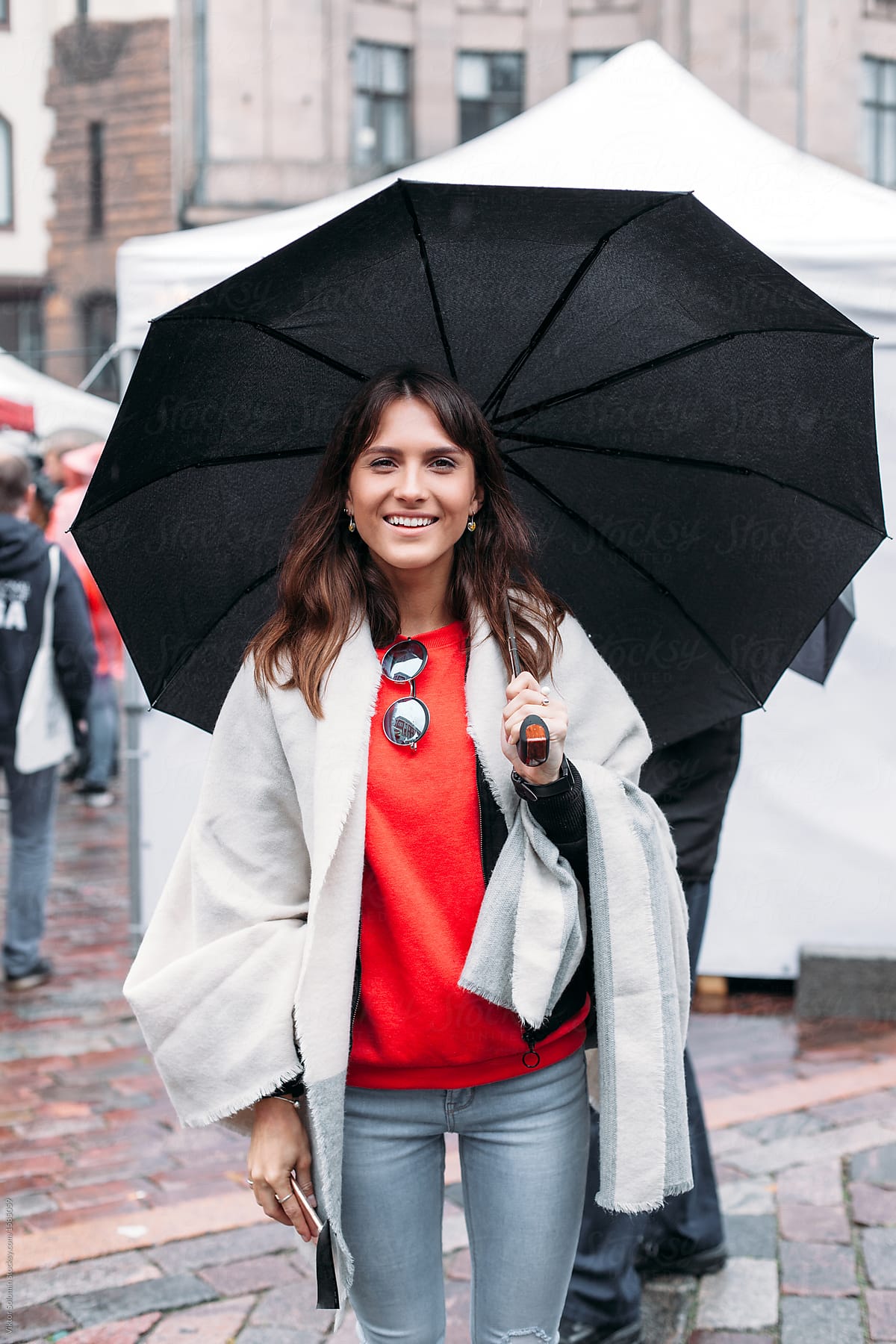 woman posing on the street in rainy day under umbrella