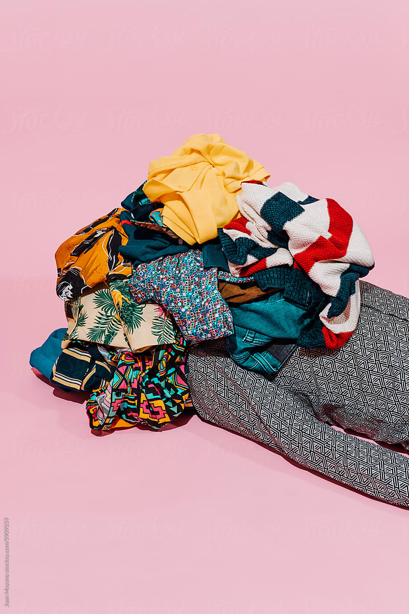 man covered by a pile of clothes