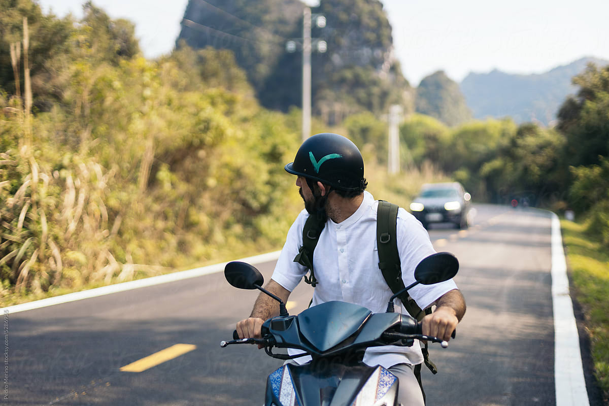 Traveler driving a scooter in the nature of Southeast Asia