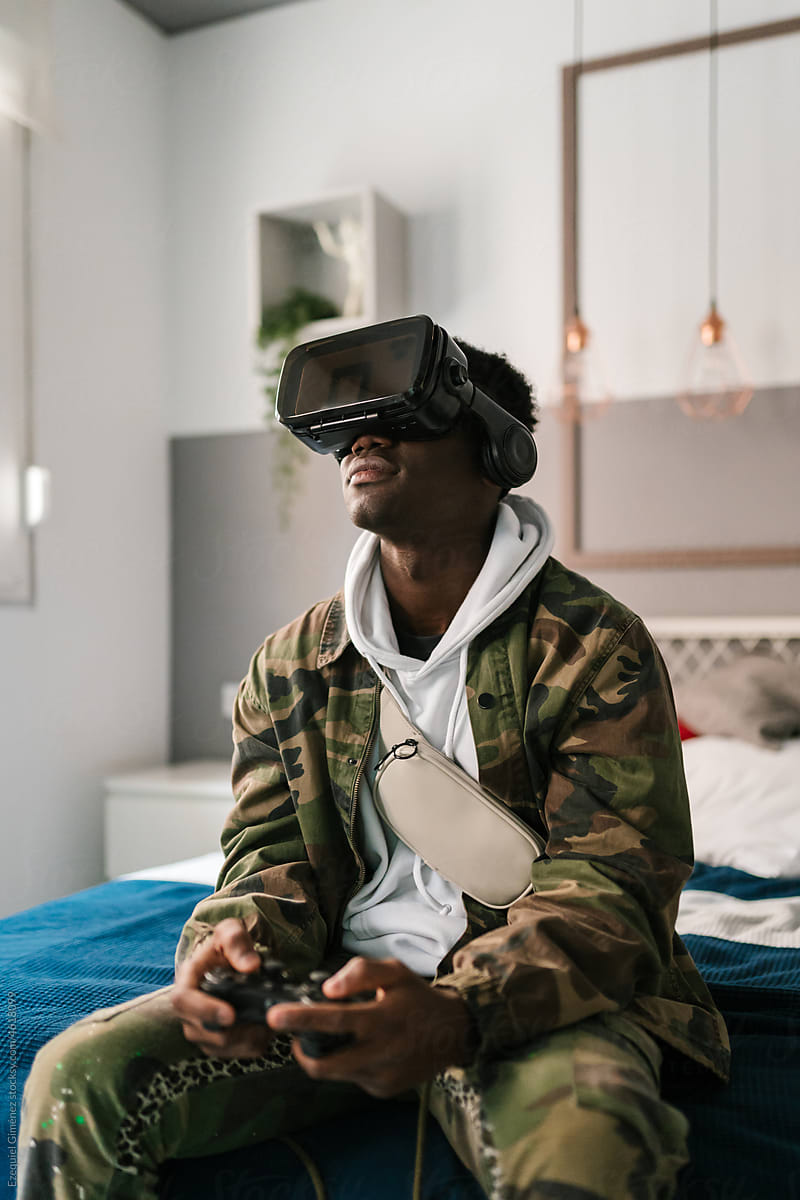 Black man in VR glasses playing videogame
