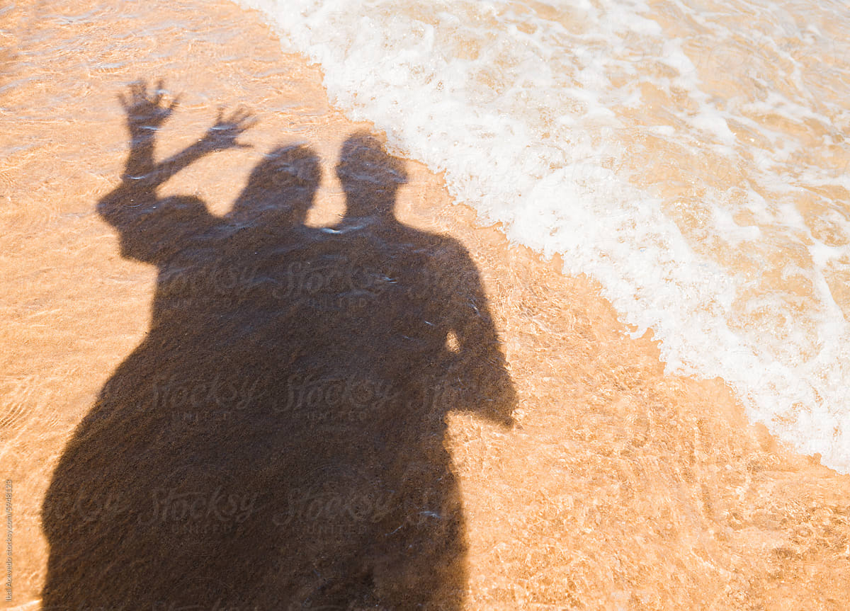 Happy couple shadow on sunny beach shore