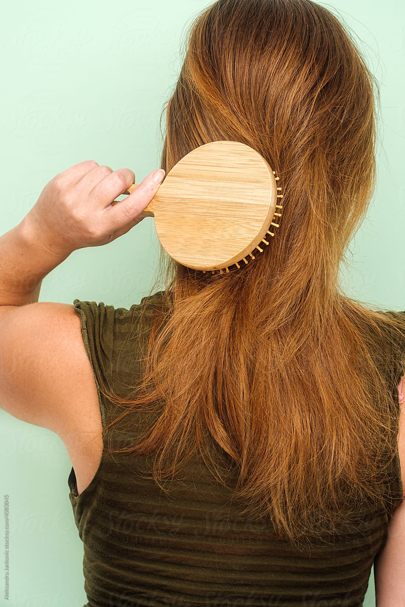 Anonymous Redhead Woman Using Wooden Hair Brush
