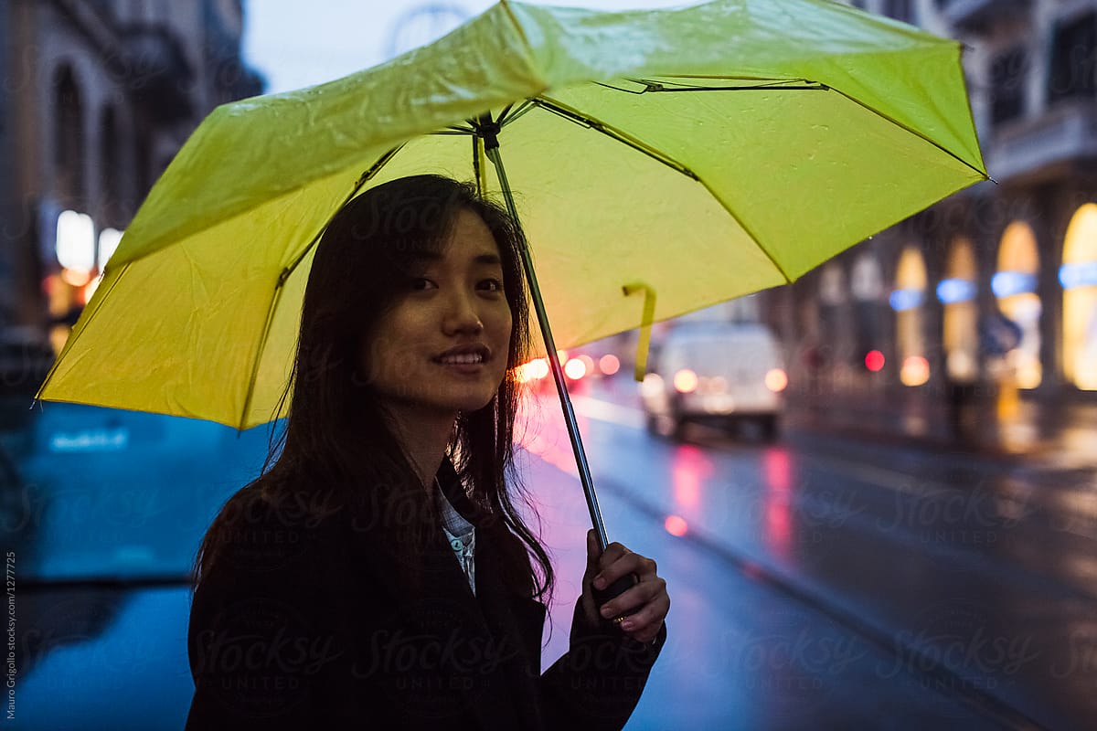 Smiling Woman On A Street At Dusk On A Rainy Day By Stocksy Contributor Mauro Grigollo Stocksy