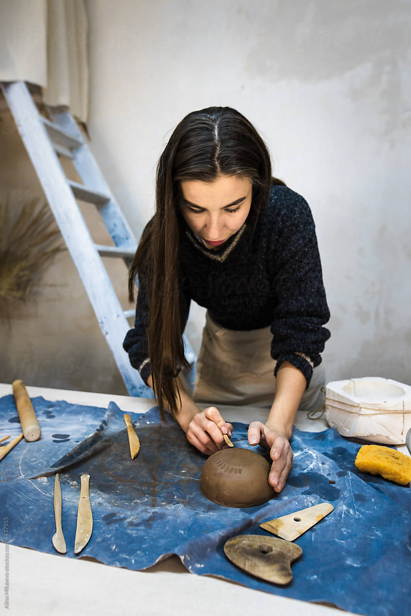 Female Potter Modeling A Ceramic Bowl