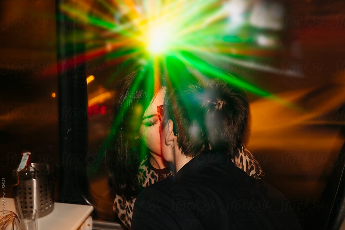 Young couple kissing in green light