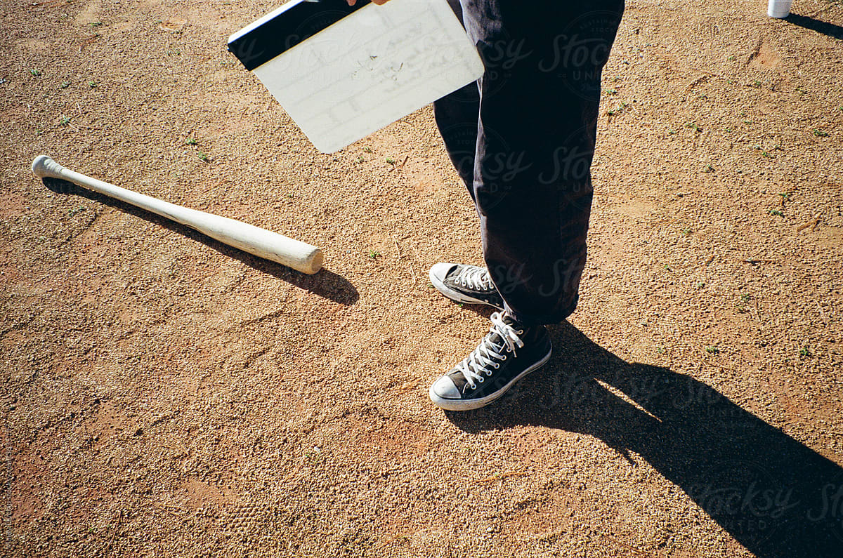 Person holding a clapboard on a baseball field