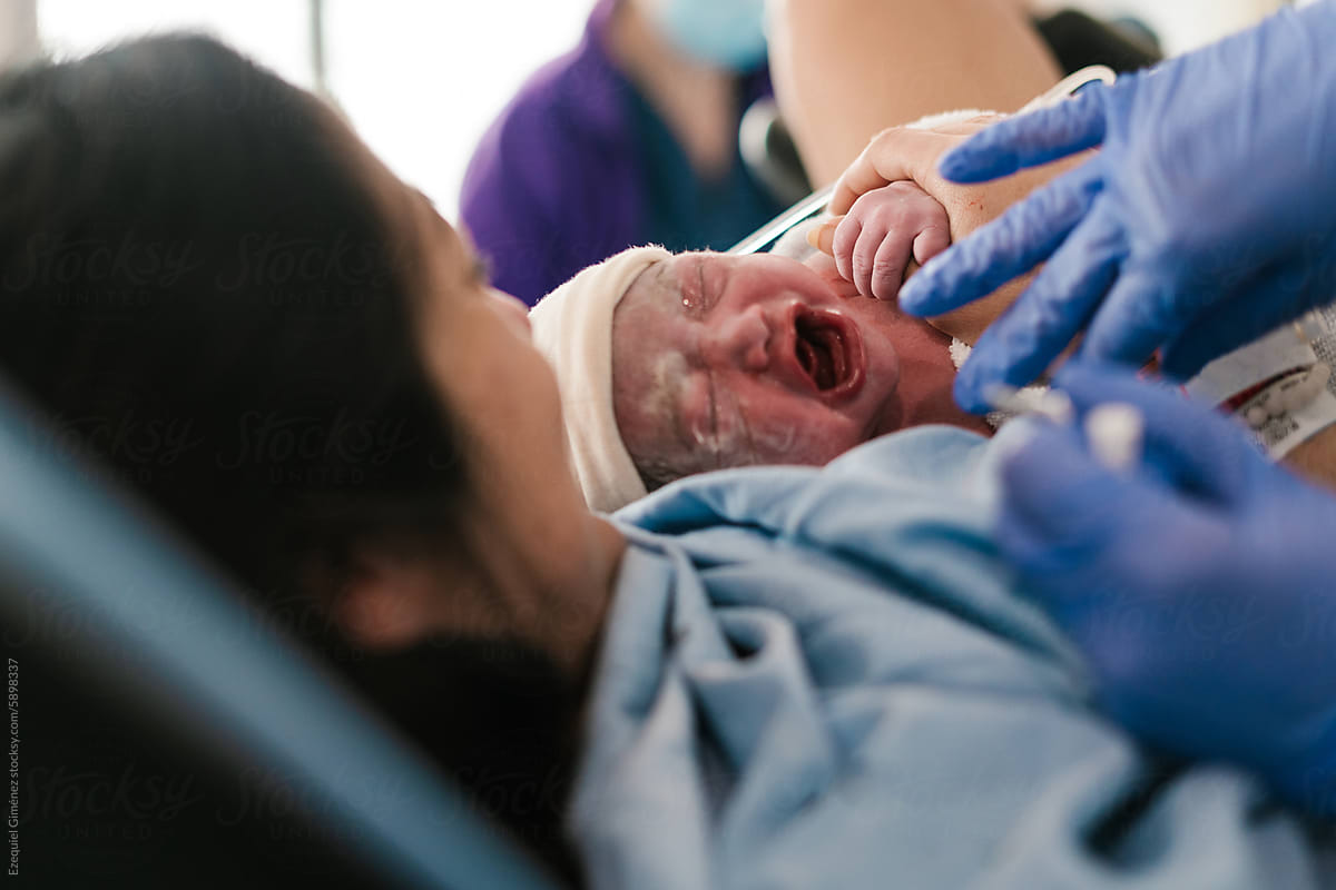 Anonymous doctor examining newborn in hospital