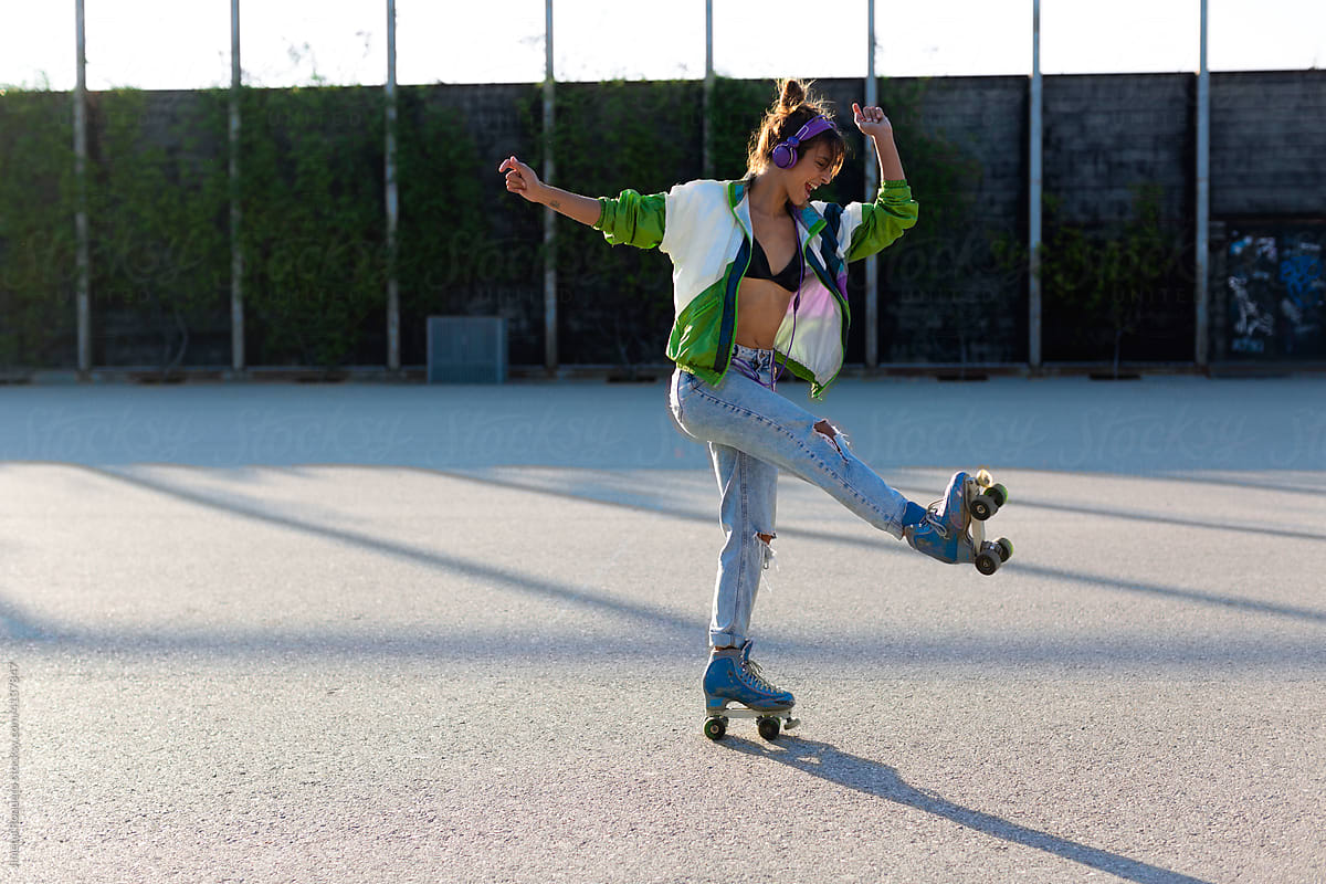 Roller-skater girl dancing cheerfully in sunlight