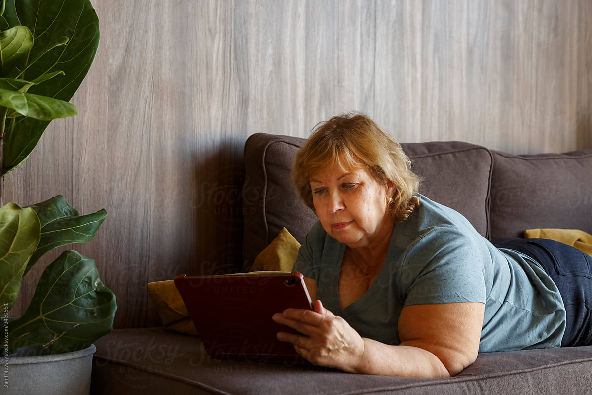 Female browsing tablet on sofa
