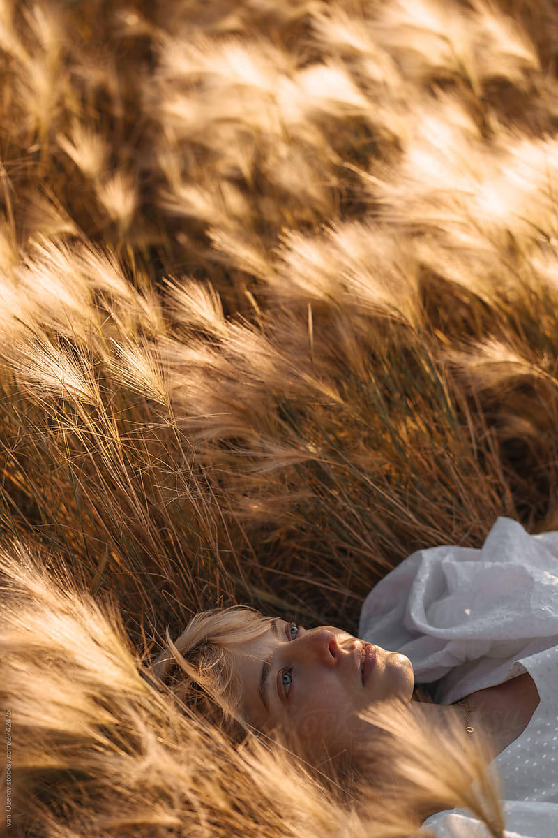 Woman Lying On Grass On Sunny Day By Stocksy Contributor Ivan Ozerov