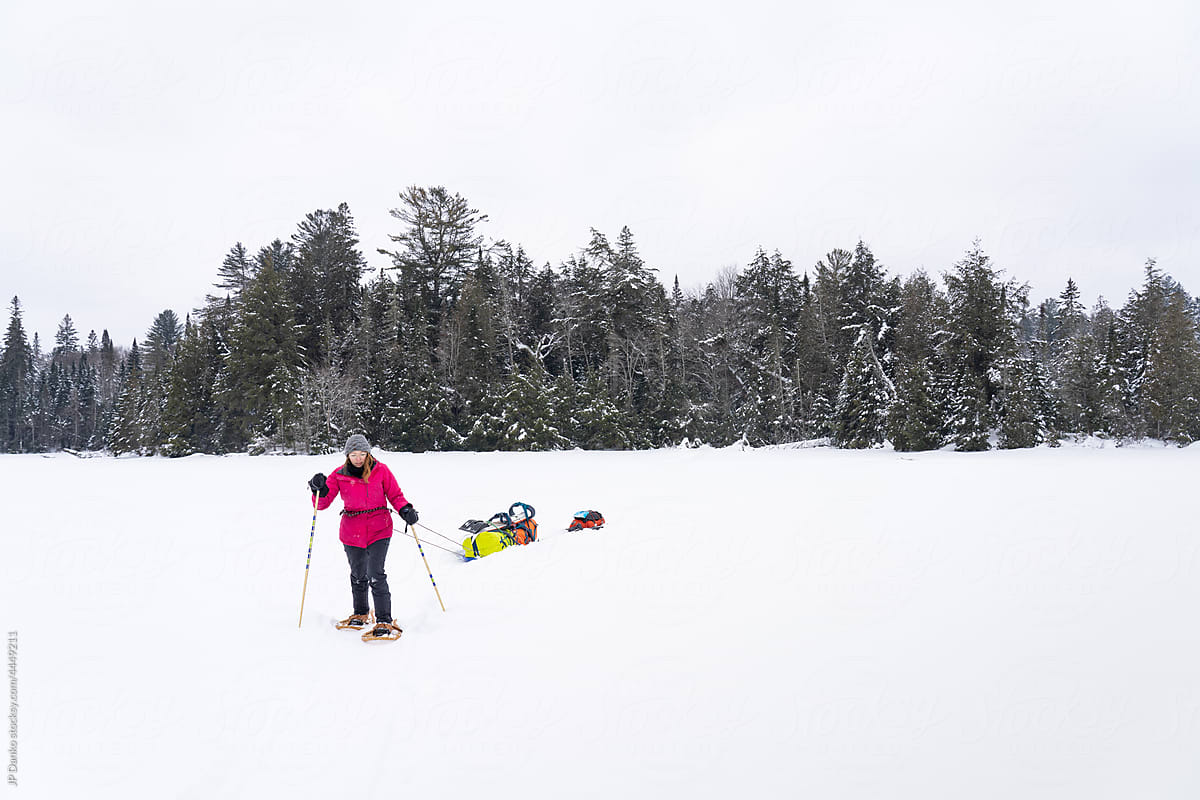 Snowshoeing with Winter Camping Gear Sled on Frozen Lake