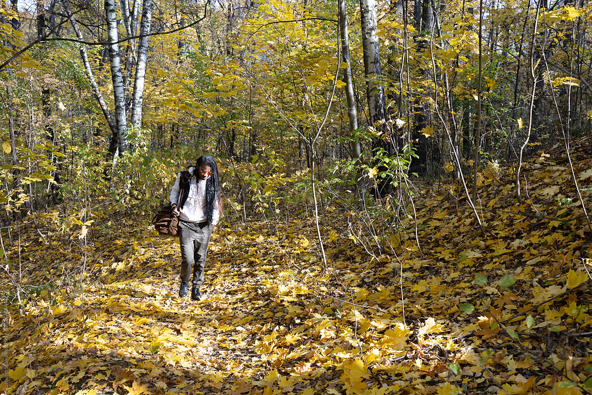 Man walking in the forest during an autumn afternoon