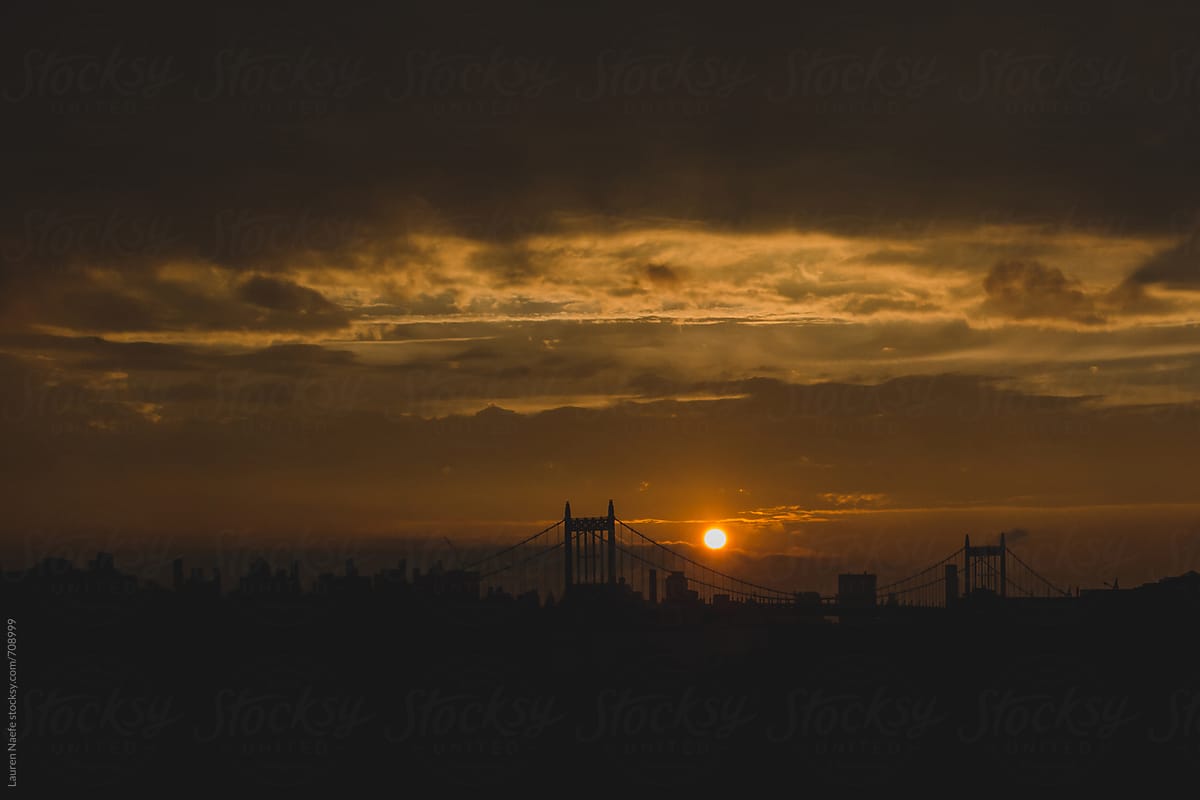 Sun setting over bridge and NYC