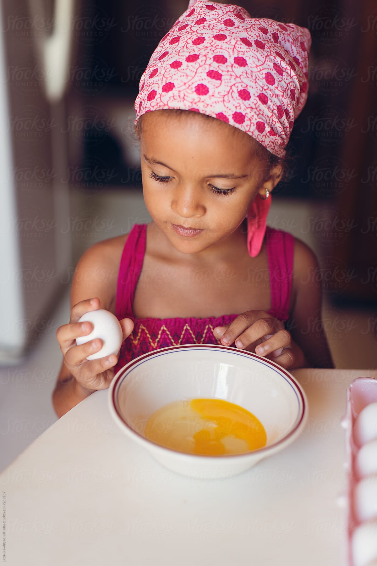Young child cracking eggs into a bowl