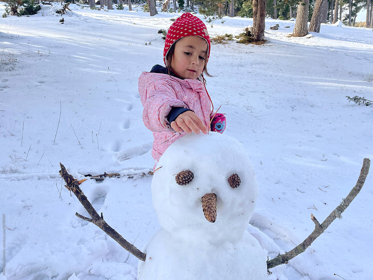 little girl making snowman