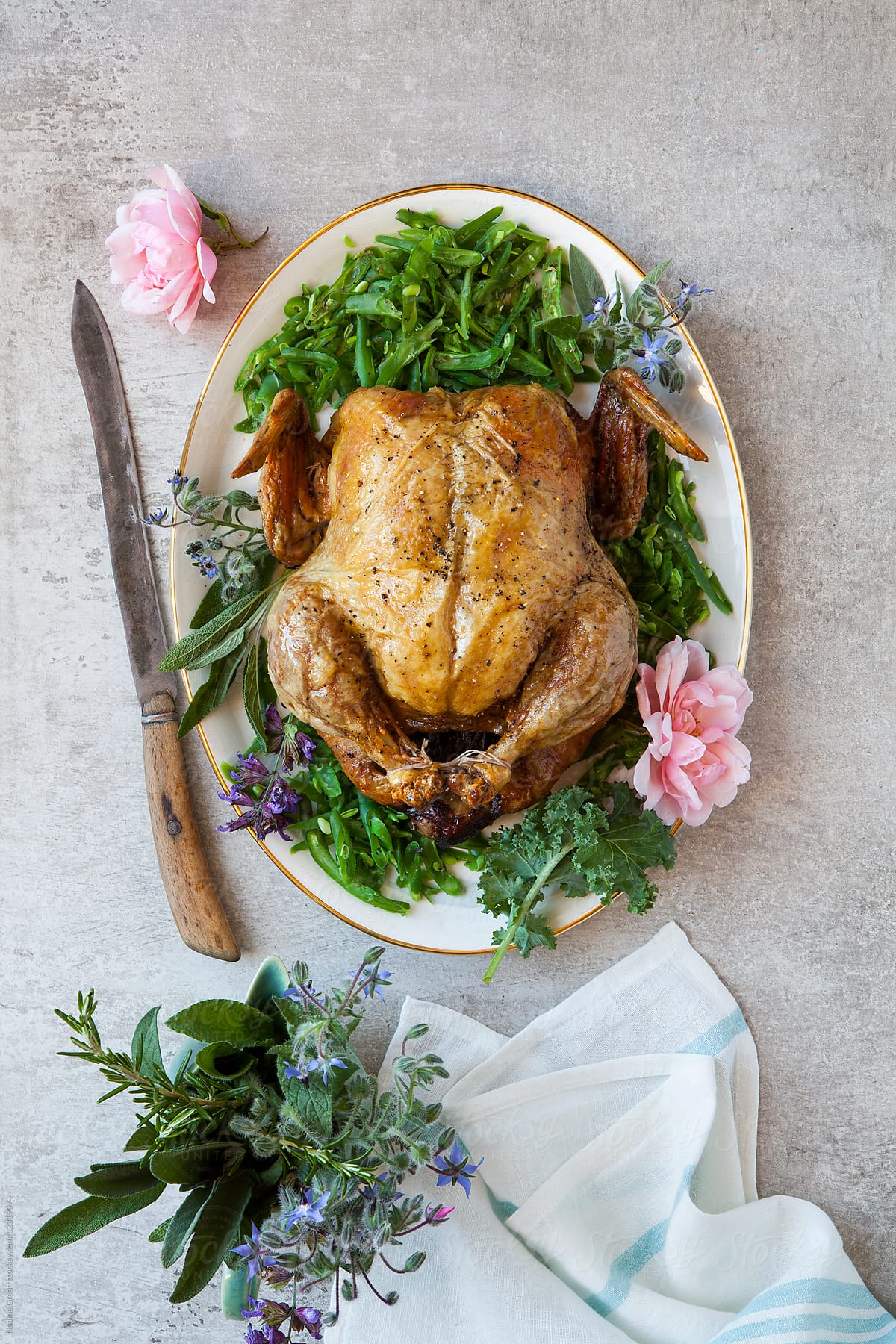 Roast chicken and green beans, decorated with flowers and herbs
