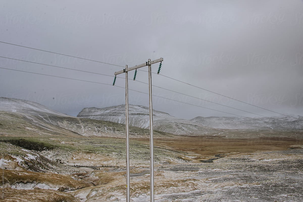 Power lines and pole stretching across a remote winter landscape.