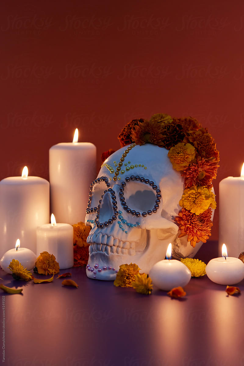 Closeup of skull in flower wreath and candles
