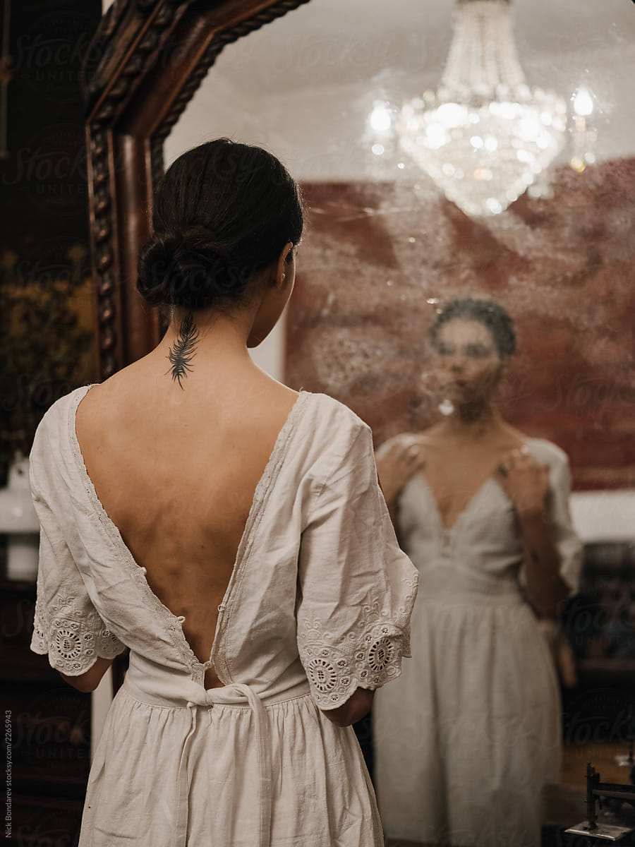 Woman in old-fashioned dress against mirror