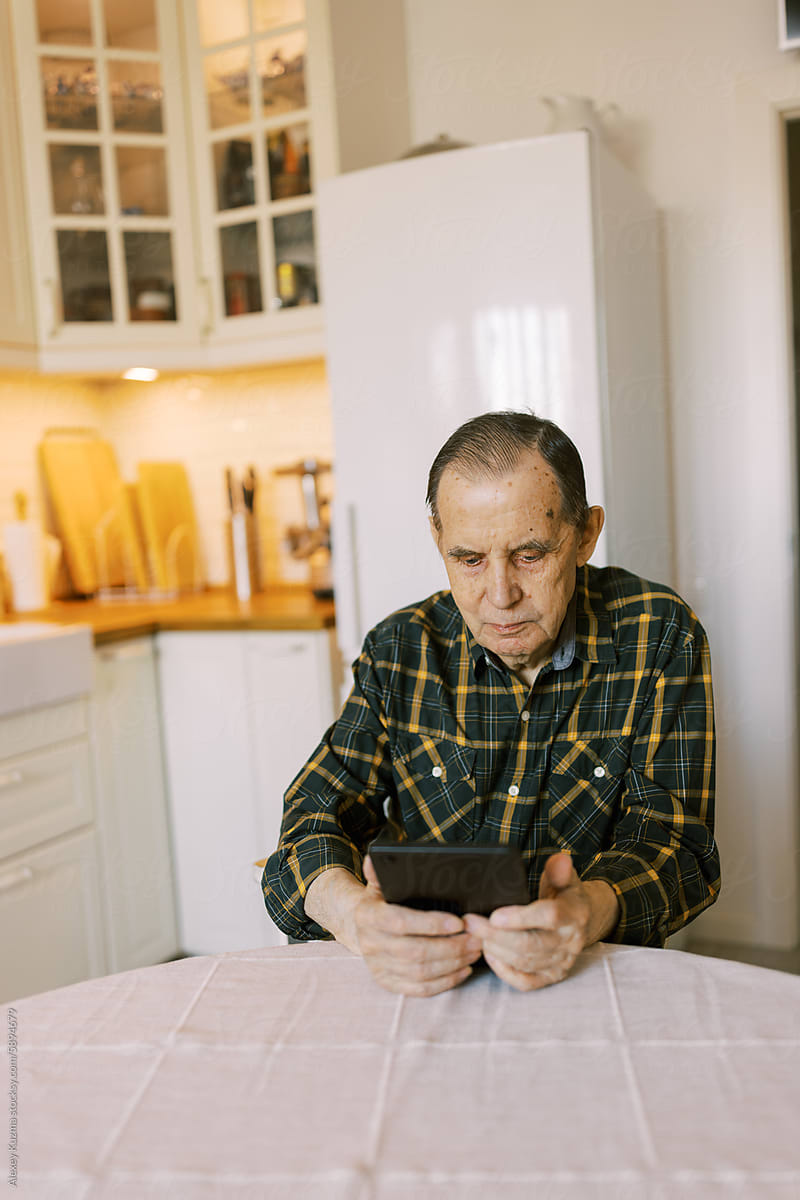 Senior man using modern digital tablet at home for video call