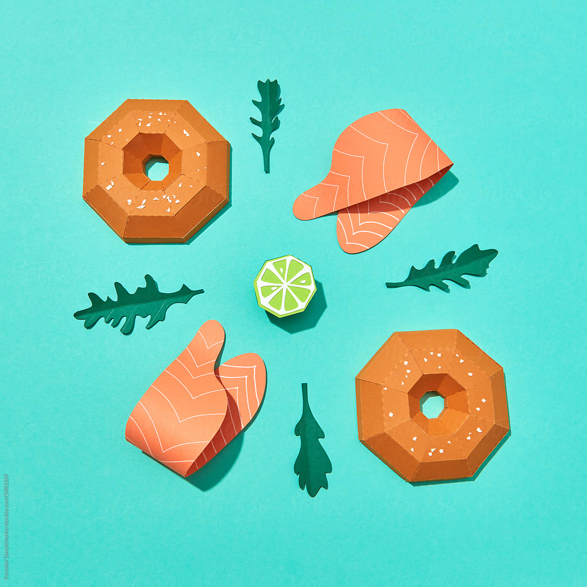 Handcraft paper half bagels, pieces of red fish, leaves and lime