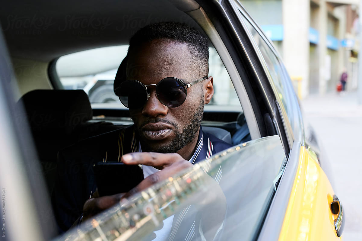 Black afro businessman backseat taxi.