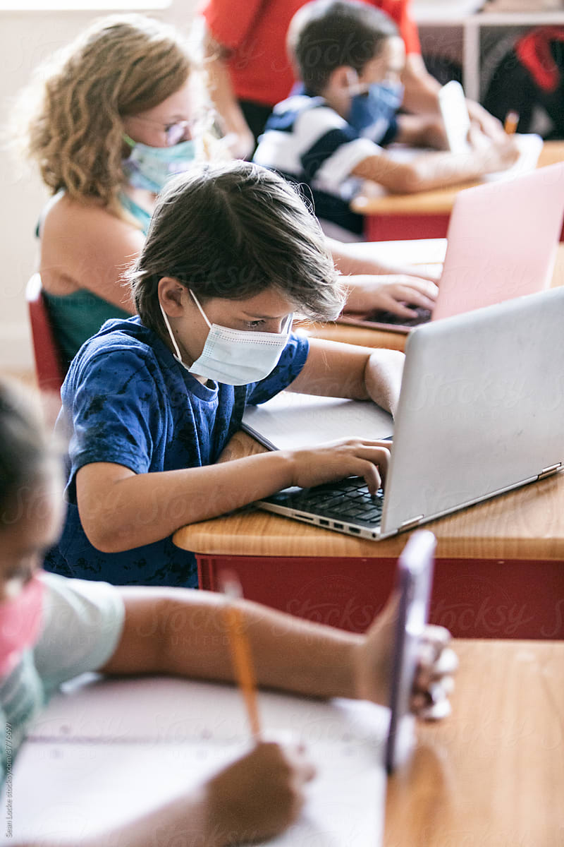 School: Boy Wearing Facemask Uses Laptop To Do Research