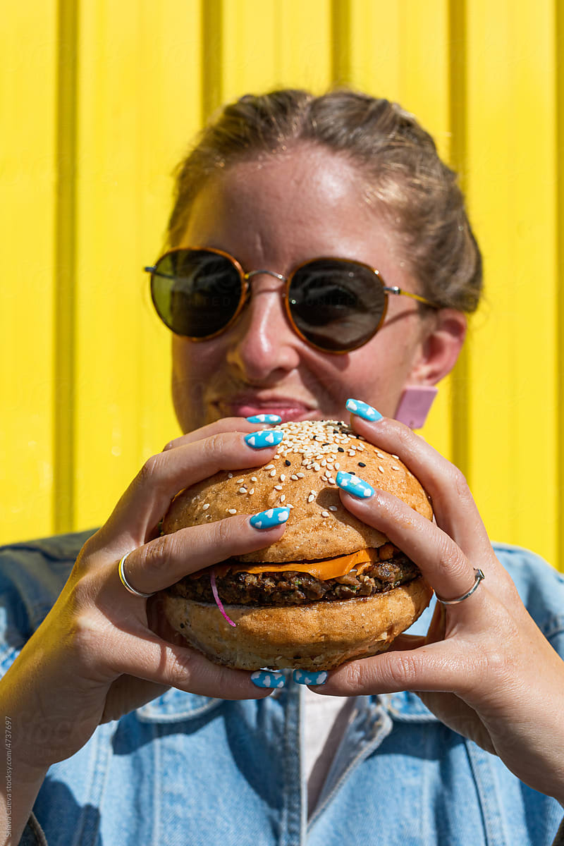 A woman holding a big hamburger