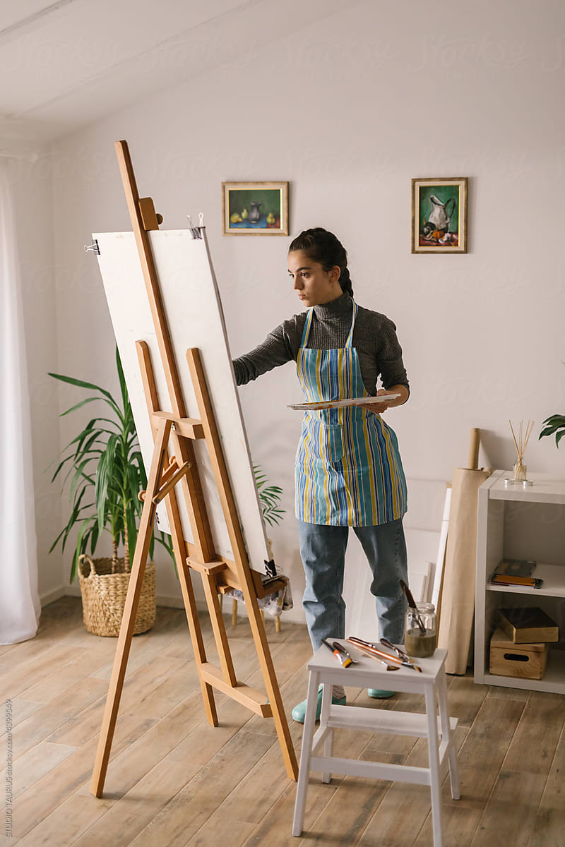 Art student in art studio painting on canvas