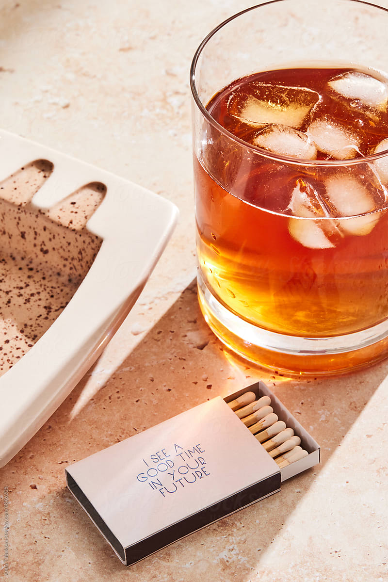 Iced whiskey drink and a box of matches