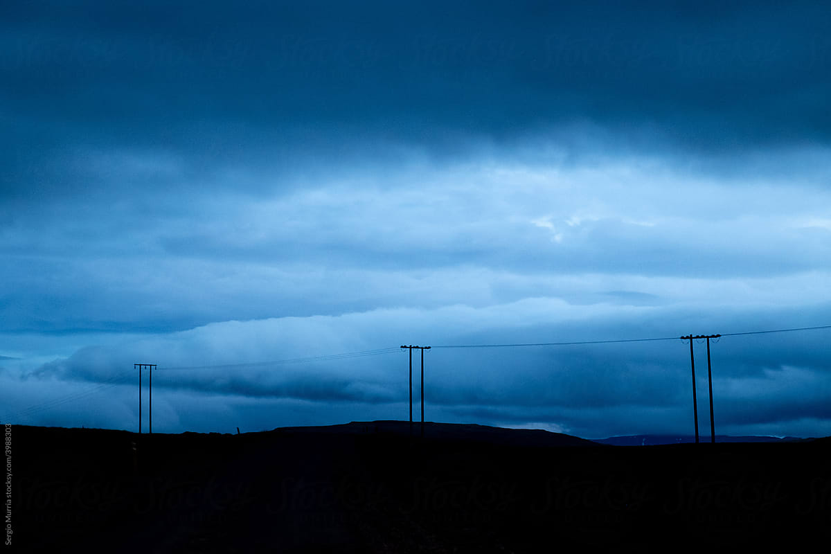 Lamp posts in the field on a bluish sunset