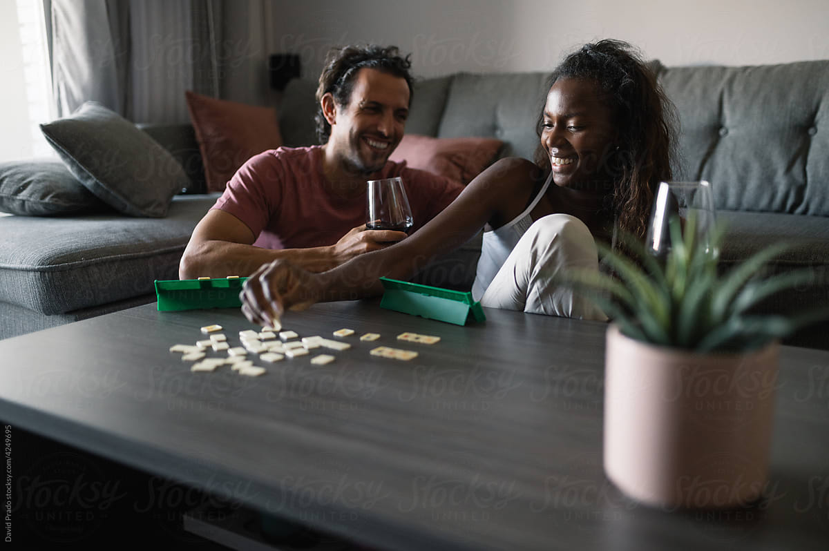 Smiling diverse couple playing board game