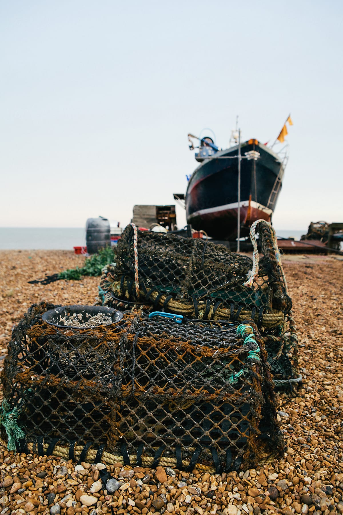 Lobster pots and fishing boat on a quiet beach in Kent.