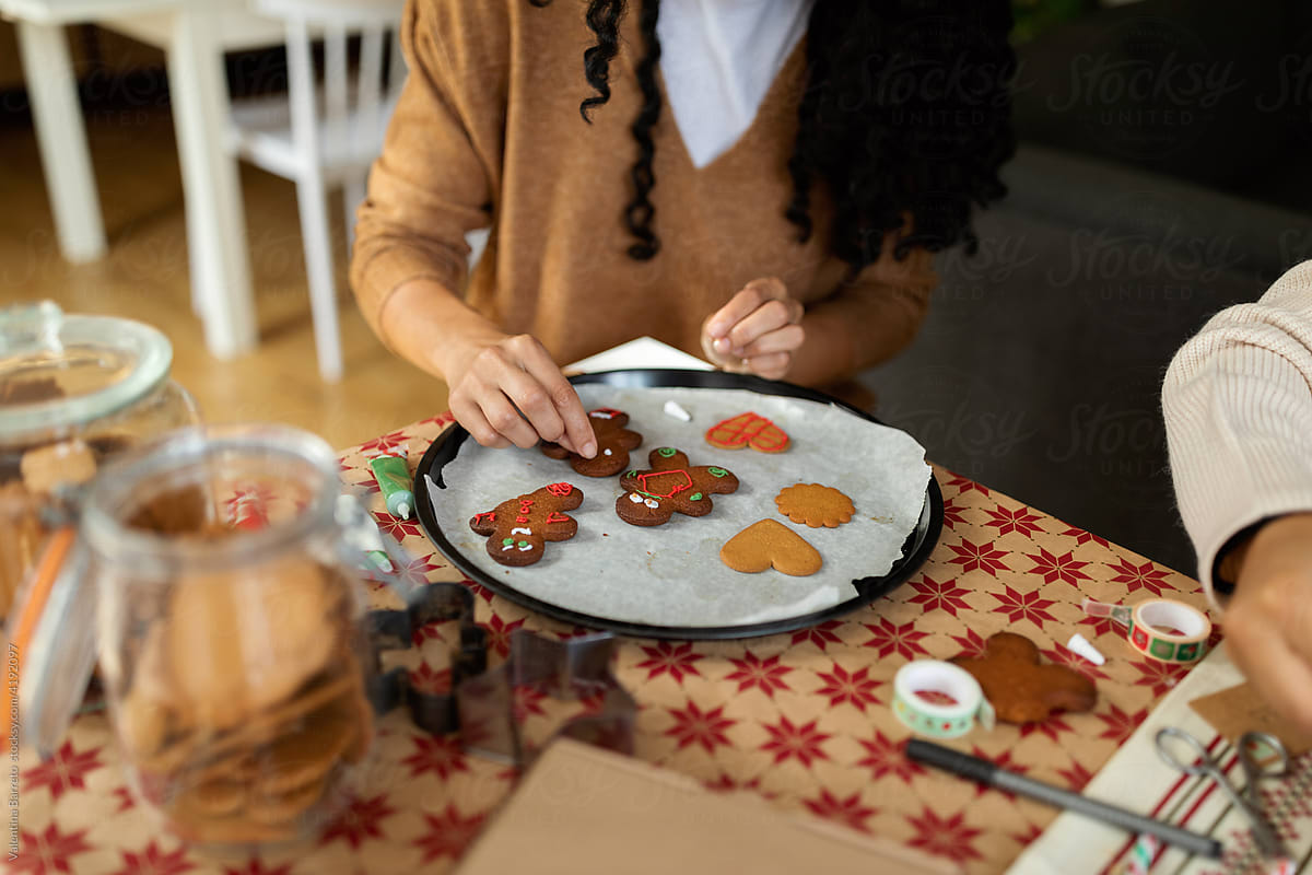 Woman decorating gingerbread at home