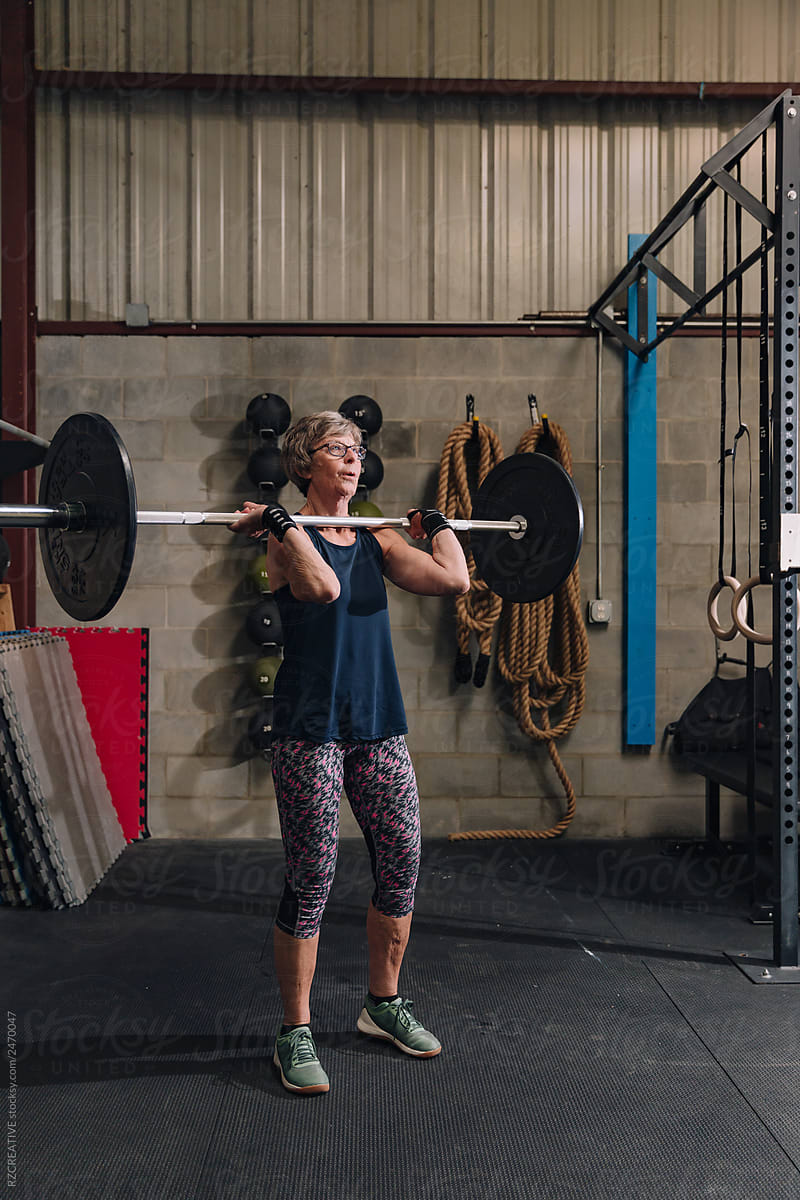 Senior woman lifting at gym.