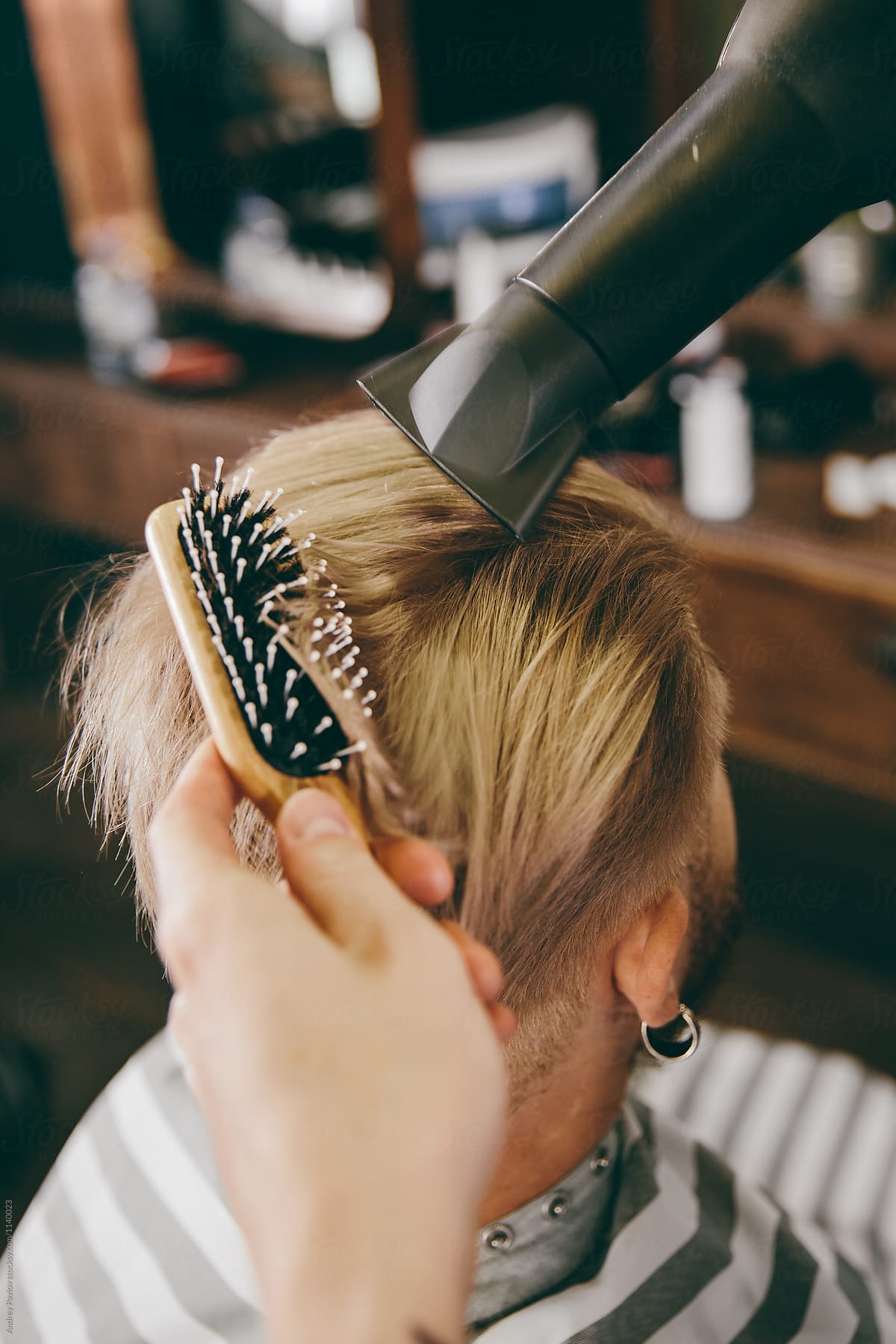Barber blowing blond client\'s hair